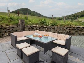 An outdoor seating area with a table and food items at Cwmwr in Penybontfawr