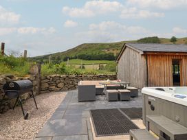 An outdoor area with a grill and hot tub at Cwmwr Penybontfawr