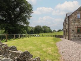 An outdoor area with lawn, fence, and chairs at Cwmwr Penybontfawr