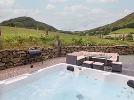 An outdoor area with a hot tub and seating at Cwmwr Penybontfawr
