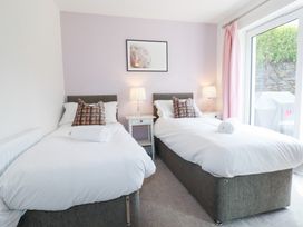 A bedroom with twin beds and a bedside table at Beach Haven in Perranporth