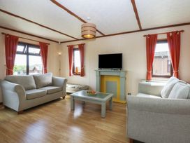 A living room with a television and sofa at 16 Forest Lodge in Chwilog