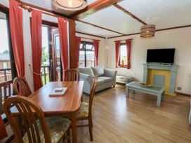 A living room with a table and chairs at 16 Forest Lodge in Chwilog