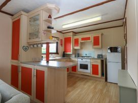 A kitchen with cabinets and appliances at 16 Forest Lodge, Chwilog
