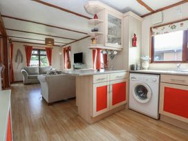 A living room with a couch and television at 16 Forest Lodge in Chwilog