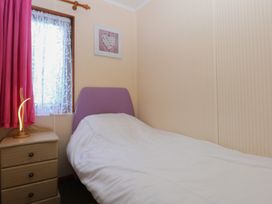 A bedroom with a bed and a window at 16 Forest Lodge in Chwilog