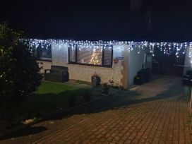 A house with decorative lights and a bench at Normandy in Nefyn