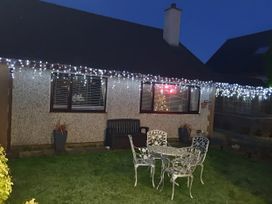 A garden with chairs and a table in front of a house at Normandy in Nefyn