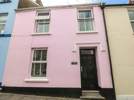 A pink house with a black door at Longmoor in Tenby