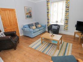 A living room with a sofa and armchair at Longmoor in Tenby