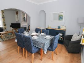 A dining room with a table set for dinner at Longmoor in Tenby