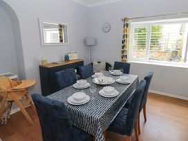 A dining room with a table set for meals at Longmoor in Tenby