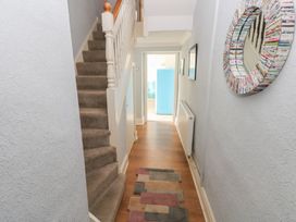 A hallway with stairs and a mirror at Longmoor in Tenby