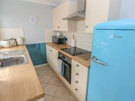 A kitchen with a sink and fridge at Longmoor in Tenby