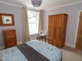 A bedroom with a bed and wardrobe at Longmoor in Tenby