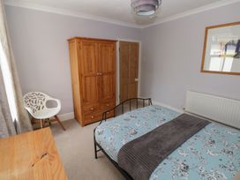 A bedroom with a bed and wardrobe at Longmoor in Tenby
