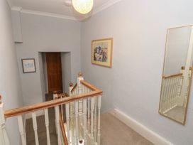 A hallway with a staircase and a painting at Longmoor in Tenby