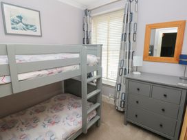 A bedroom with a bunk bed and dresser at Longmoor in Tenby