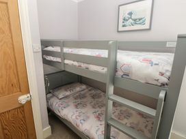 A bedroom with a bunk bed and artwork at Longmoor in Tenby