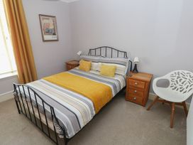 A bedroom with a bed and nightstand at Longmoor in Tenby