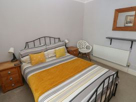 A bedroom with bed and bedside table at Longmoor in Tenby