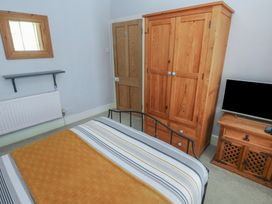 A bedroom with a bed and wardrobe at Longmoor in Tenby