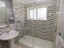 A bathroom with a shower and wash basin at Longmoor in Tenby