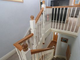 A staircase with a handrail in a hallway at Longmoor in Tenby