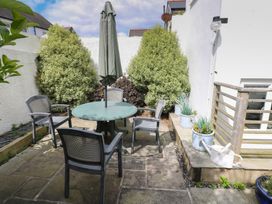 A garden area with a table and chairs at Longmoor in Tenby