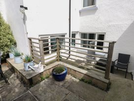 An outdoor area with a wooden balcony and planters at Longmoor in Tenby