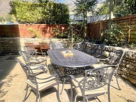 A garden with a dining table and chairs at The Grain Store in Weymouth
