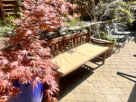 A garden with a wooden bench and potted plants at The Grain Store in Weymouth