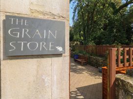A sign for The Grain Store next to a path and plants at The Grain Store in Weymouth