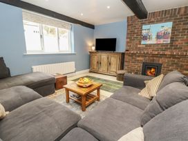A living room with a sofa, coffee table, and television at The Grain Store in Weymouth