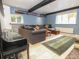 A living room with a sofa and piano at The Grain Store in Weymouth