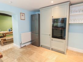 A kitchen with refrigerator, oven and dining table at The Grain Store in Weymouth