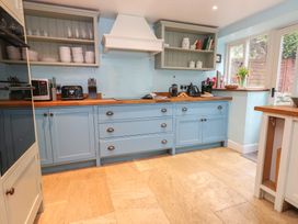 A kitchen with blue cabinets and wooden countertop at The Grain Store in Weymouth