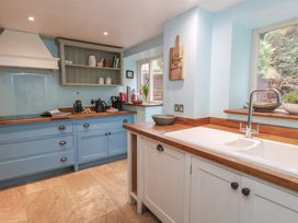 A kitchen with cabinets and sink at The Grain Store in Weymouth
