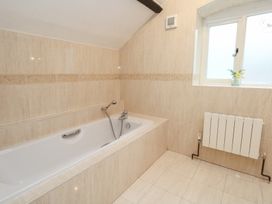 A bathroom with a bathtub and window at The Grain Store in Weymouth