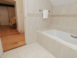 A bathroom with a bath tub and a doorway at The Grain Store in Weymouth
