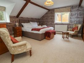A bedroom with a bed and chairs at The Grain Store in Weymouth