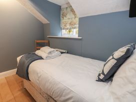 A bedroom with a single bed and a chair at The Grain Store in Weymouth