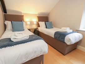 A bedroom with two single beds and bedside lamps at The Grain Store in Weymouth