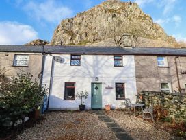An outdoor view of a house with a stone wall and pathway at Bridgeway House in Blaenau Ffestiniog