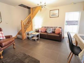 A living room with a sofa and a staircase at Bridgeway House in Blaenau Ffestiniog