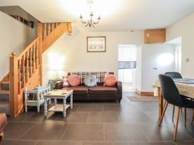 A living room with a sofa and staircase at Bridgeway House in Blaenau Ffestiniog