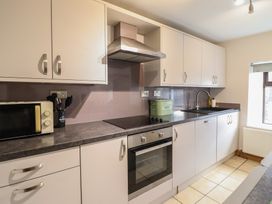 A kitchen with cabinets and appliances at Bridgeway House in Blaenau Ffestiniog