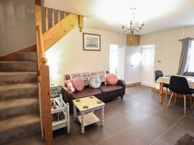 A living room with a sofa and staircase at Bridgeway House in Blaenau Ffestiniog