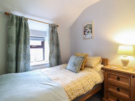 A bedroom with a bed and window at Bridgeway House in Blaenau Ffestiniog