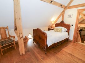 A bedroom with a bed and chair at Rookery Hall in Middle Hill near Broadway